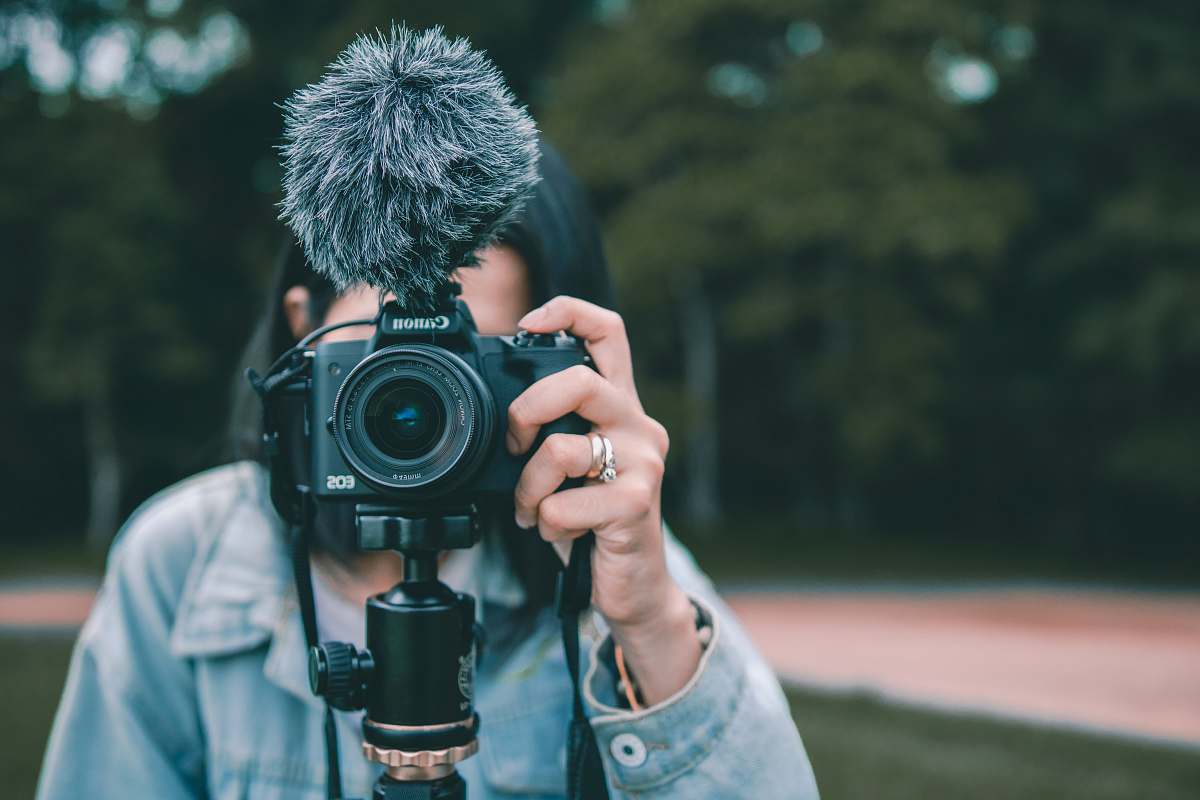 person woman holding black Canon DSLR camera human