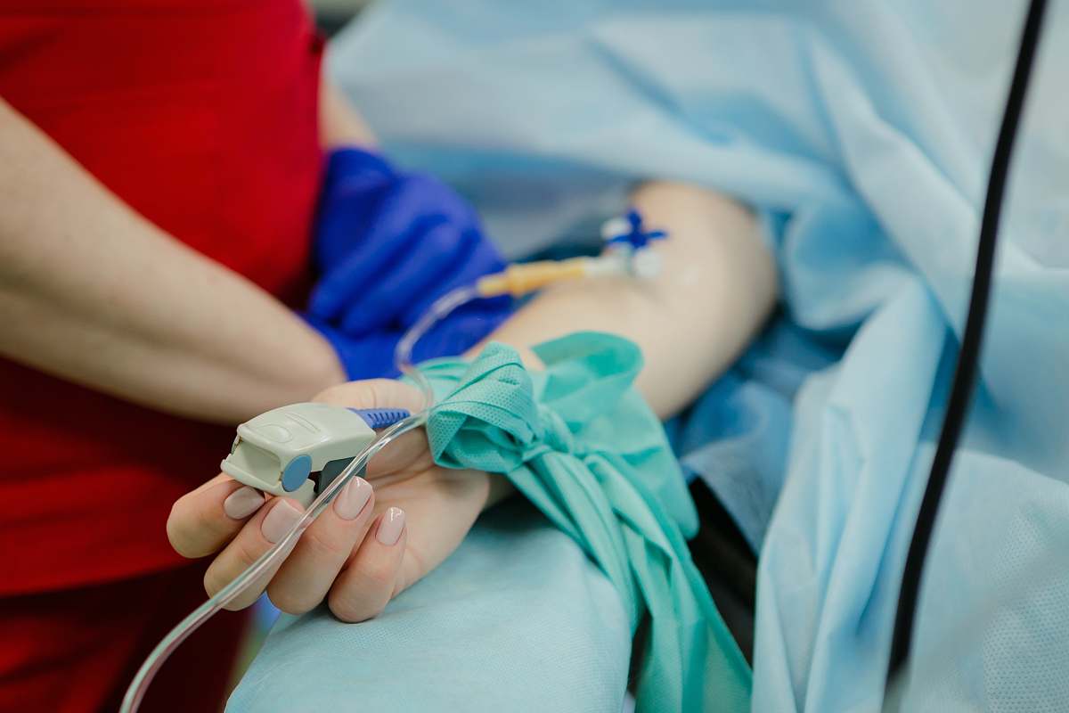 hospital person lying on bed and another person standing person