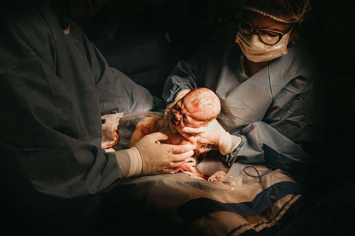 surgery two person holding newborn baby hospital