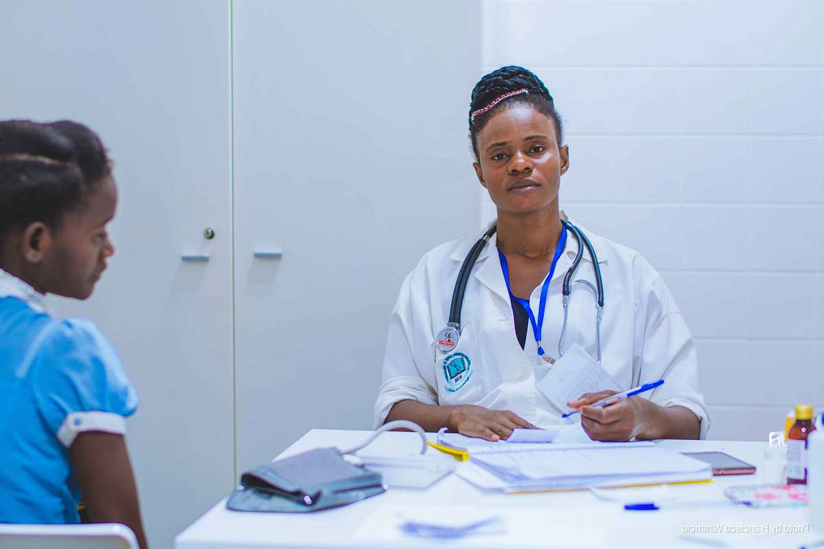 person doctor sitting at the table in front of girl human