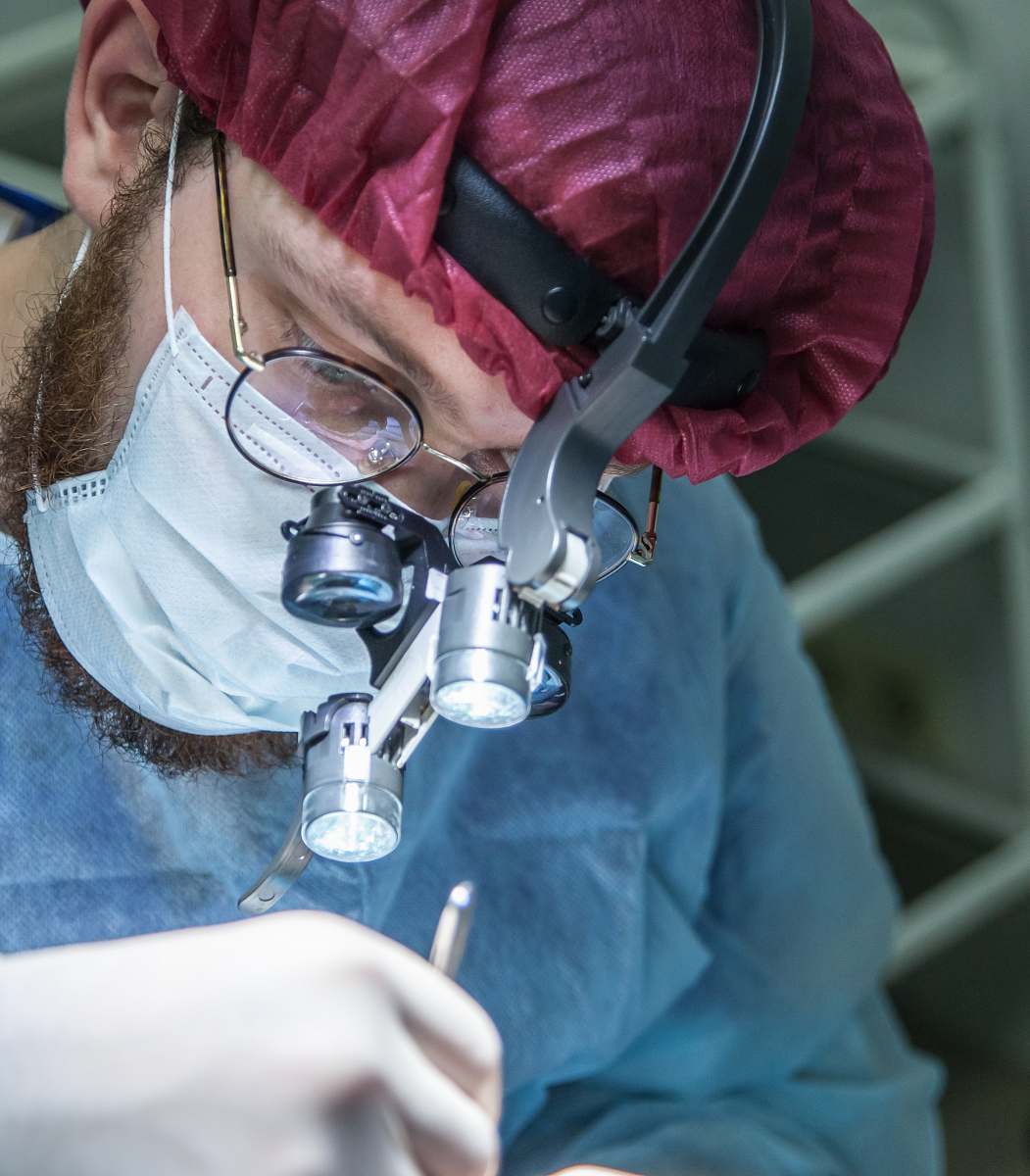 surgeon man wearing head microscope clinic
