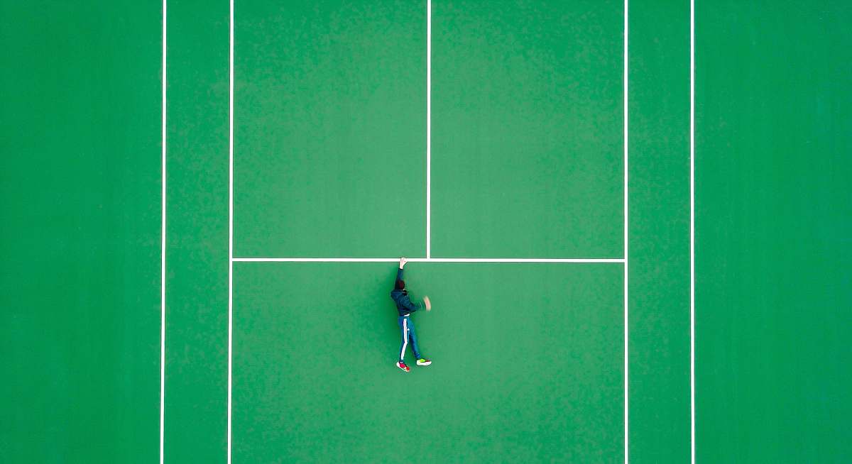 tennis aerial photography of person lying on tennis court sport