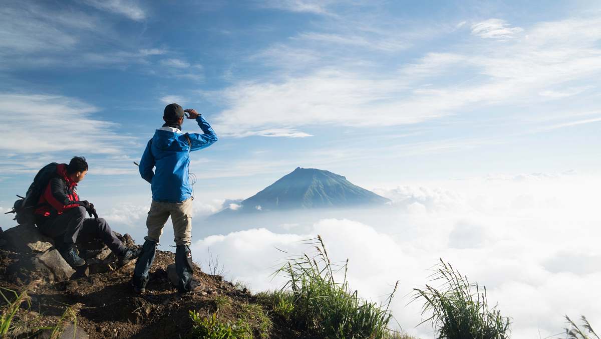 Capture the essence of adventure with this stunning photo of two individuals at the peak of a breathtaking mountain. This image showcases a man and a woman reveling in the beauty of nature, with panoramic views stretching out beneath them. Perfect for travel blogs, outdoor lifestyle articles, or promotional materials for adventure tourism, this scene embodies the spirit of exploration and the thrill of reaching new heights.