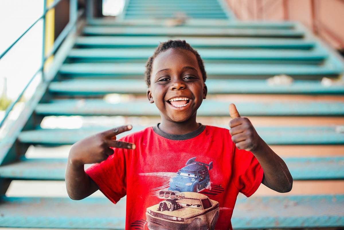 people boy standing near stairs doing peace sign at daytime person
