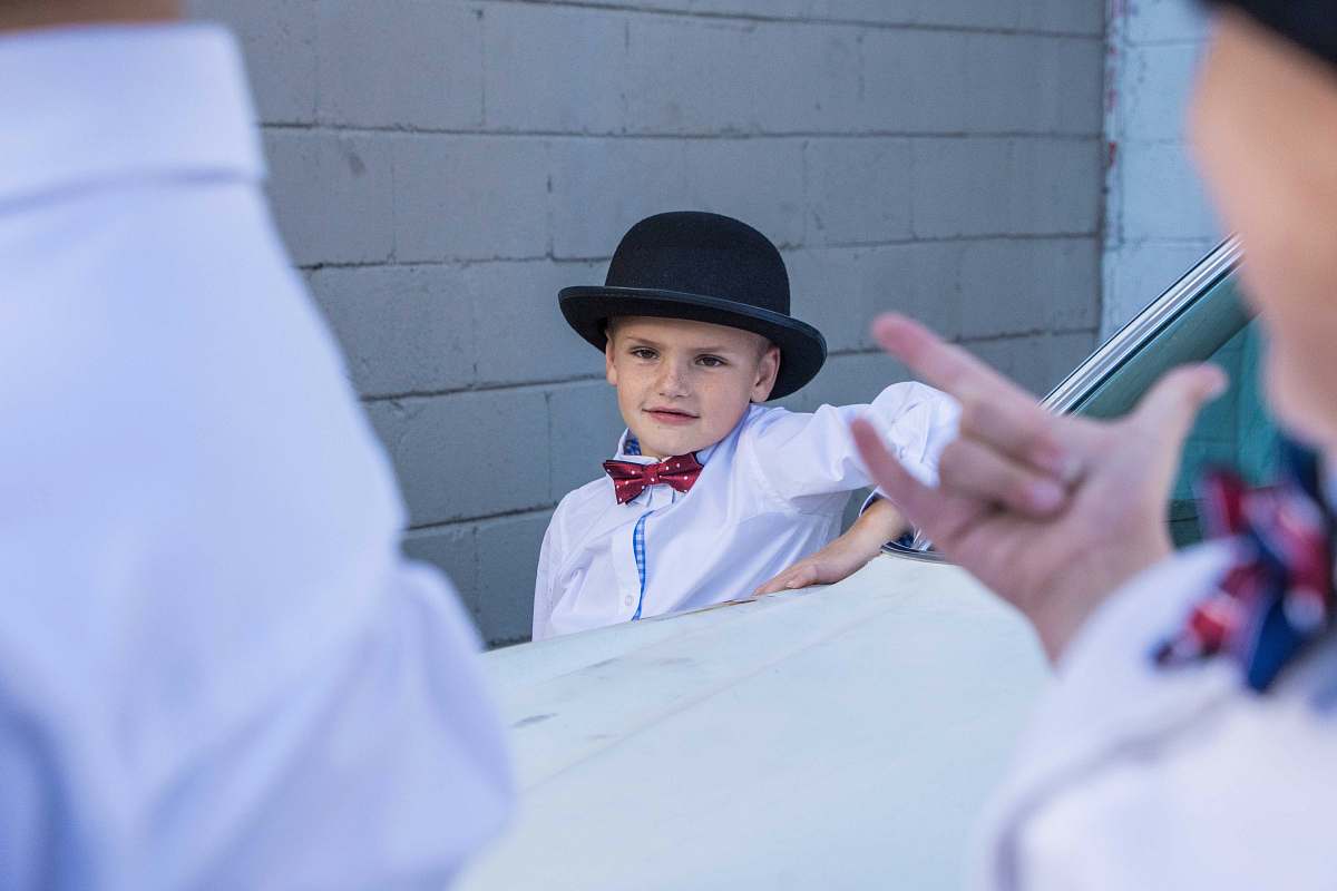 person boy standing on side of white car people