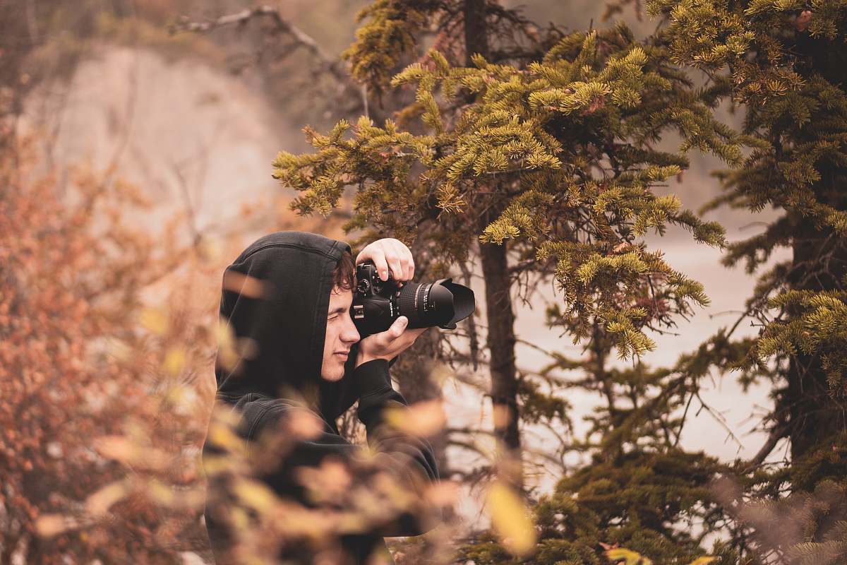 person man about to take a photo using black DSLR camera photo