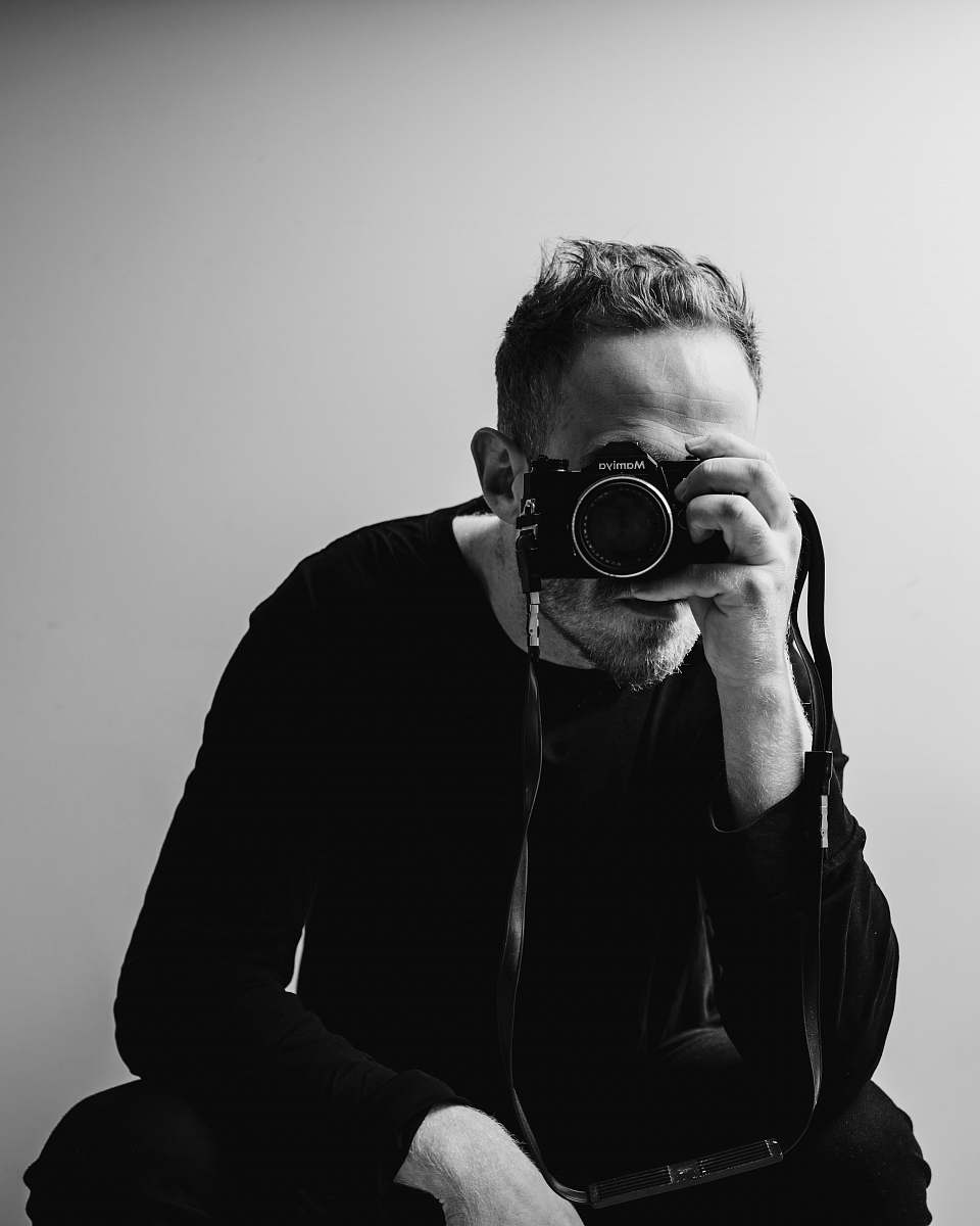 person man holding DSLR camera black-and-white