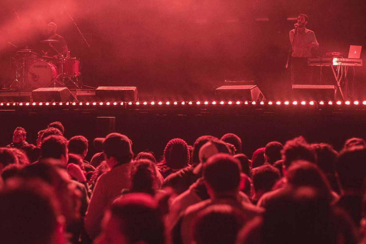 red man singing in front of group of people crowd