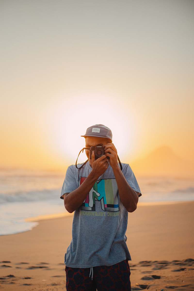 person man taking photo on seashore photography