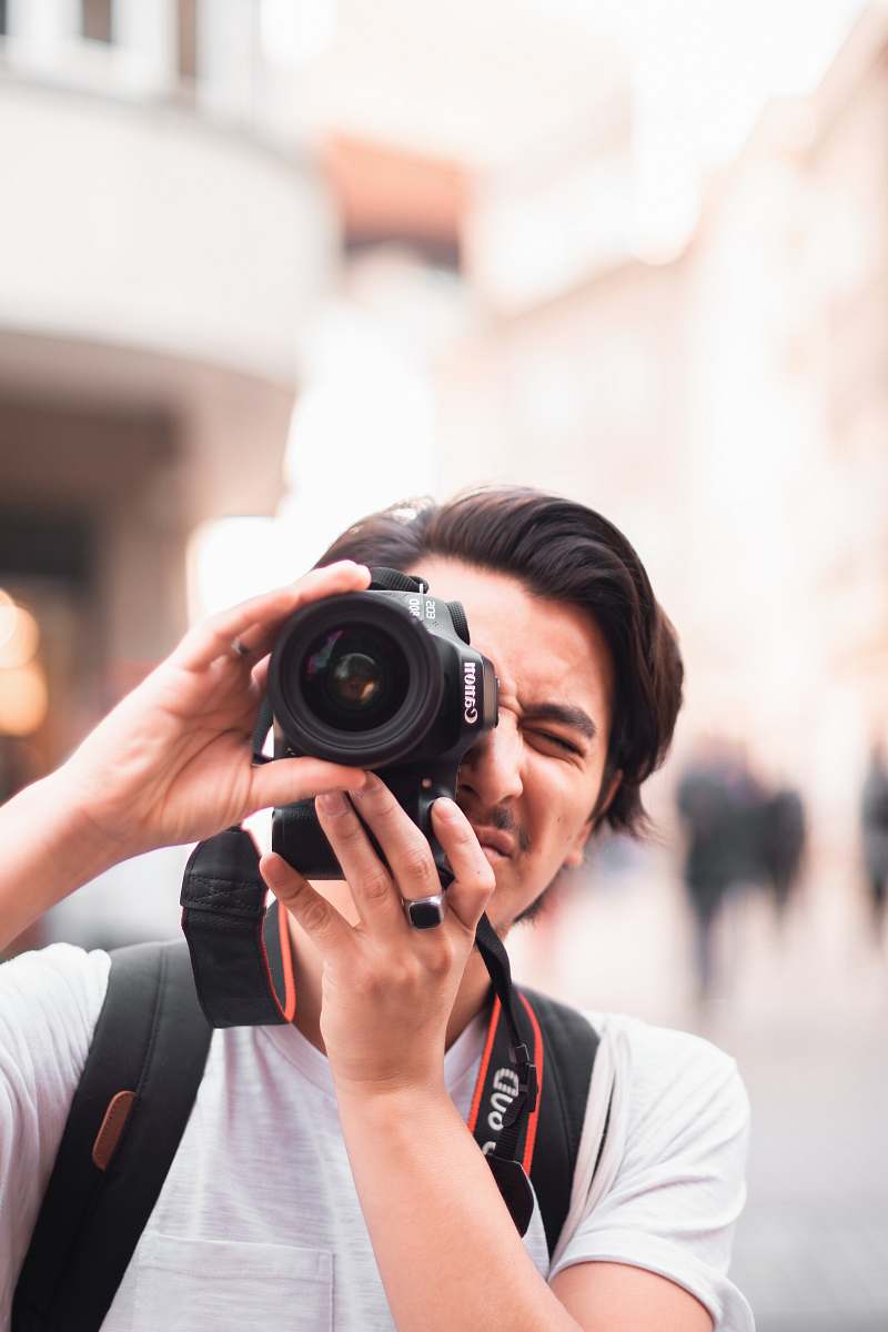 person man taking photo using Canon DSLR camera camera