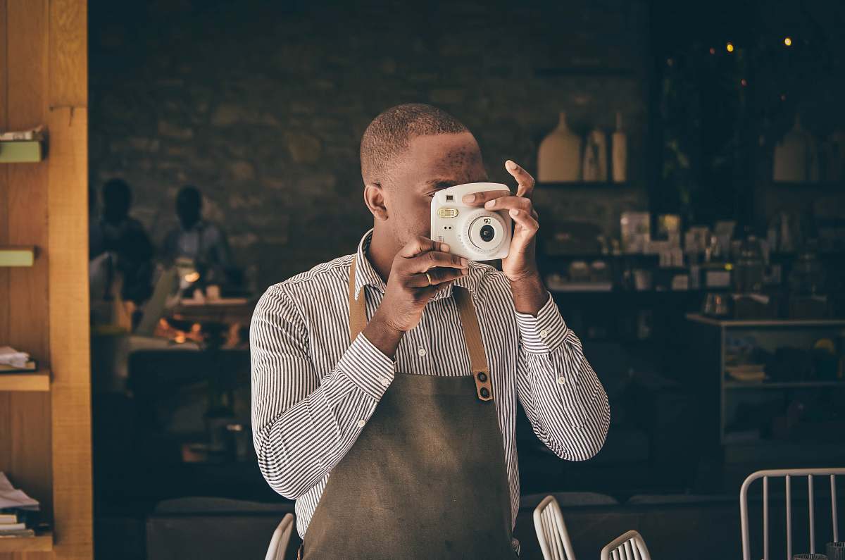 This captivating image features a man skillfully using a camera to take a self-portrait, showcasing not only his photography skills but also his creative spirit. Perfect for articles on photography, self-expression, or personal branding, this scene encapsulates the modern pursuit of capturing one's identity through the lens. Ideal for blogs, marketing materials, or social media posts that celebrate individuality and creativity.