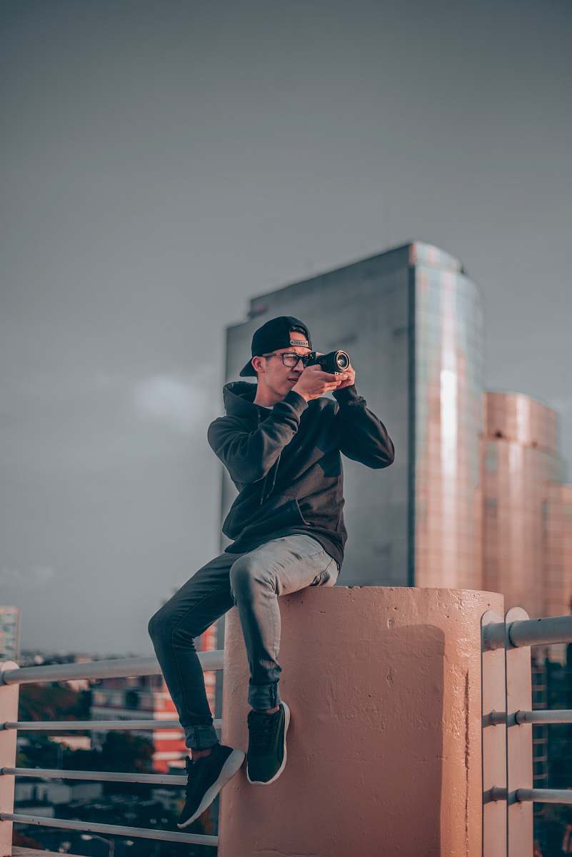 person man wearing black cap taking photo photo