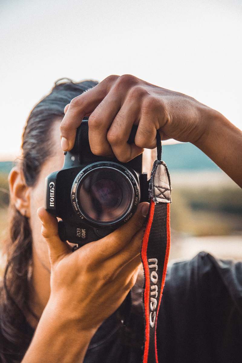 person person holding black Canon camera close-up photography camera