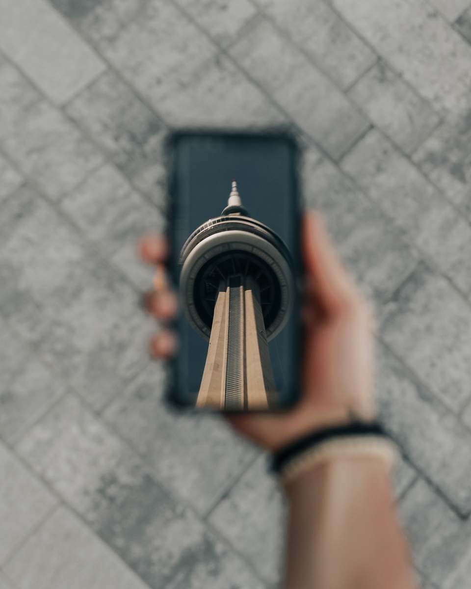 person person holding CN Tower print phone case wristwatch