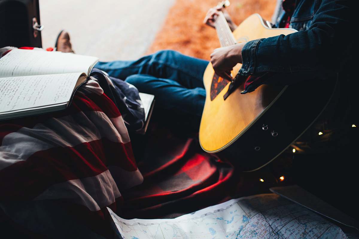 person person playing guitar while looking at lyrics music