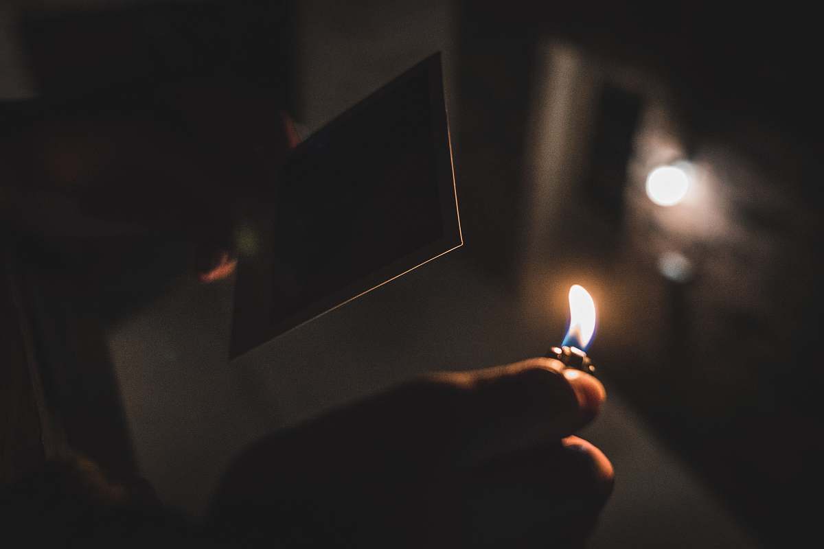 fire shallow focus photography of person holding a lighter flame