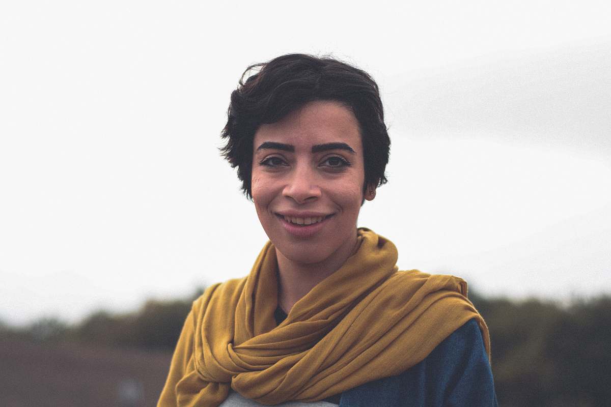 apparel smiling woman in blue top and brown scarf clothing