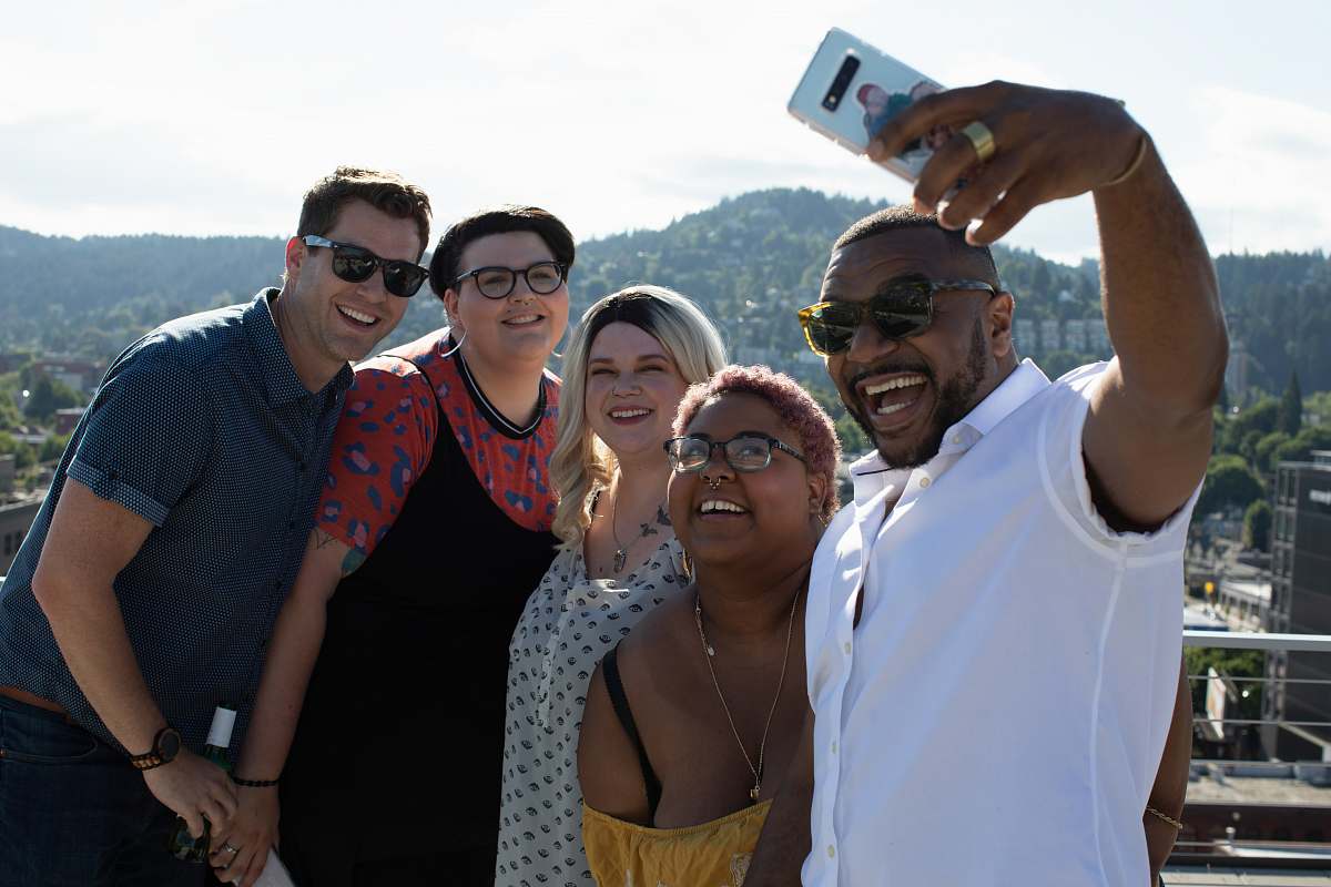 person three women and two men standing and smiling face