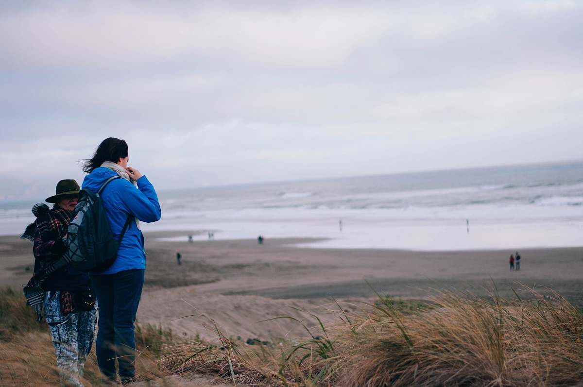 person two person standing near green field viewing sea photo