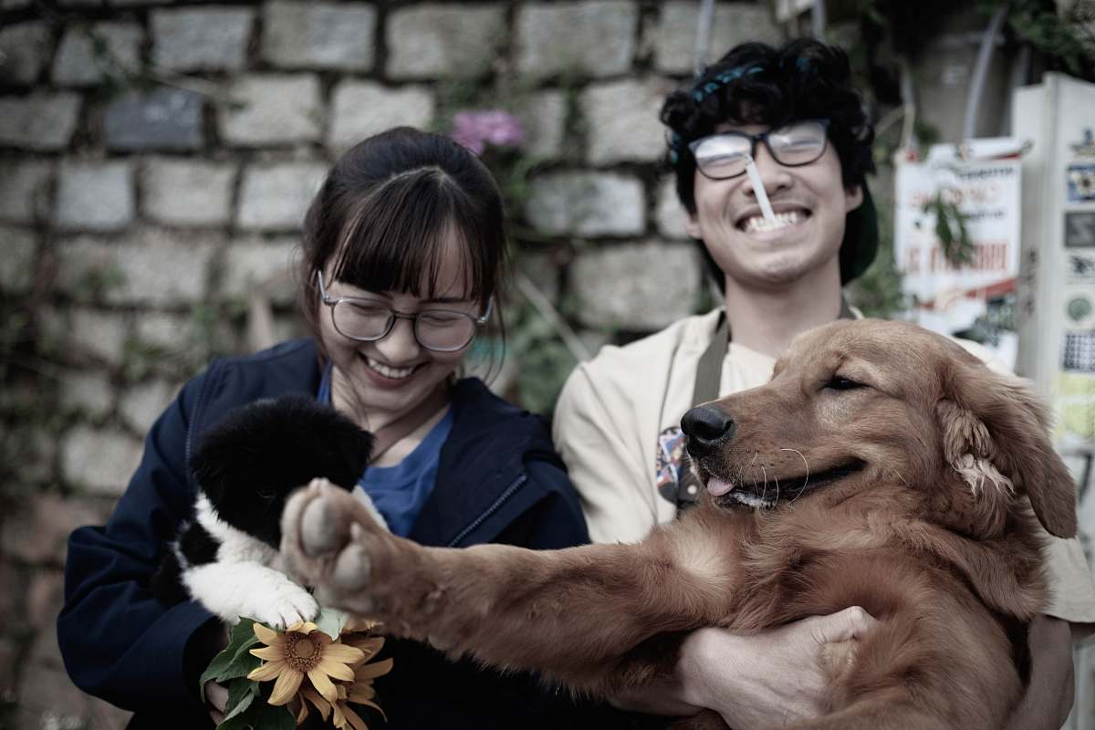 person two smiling woman and man while carrying dog accessories