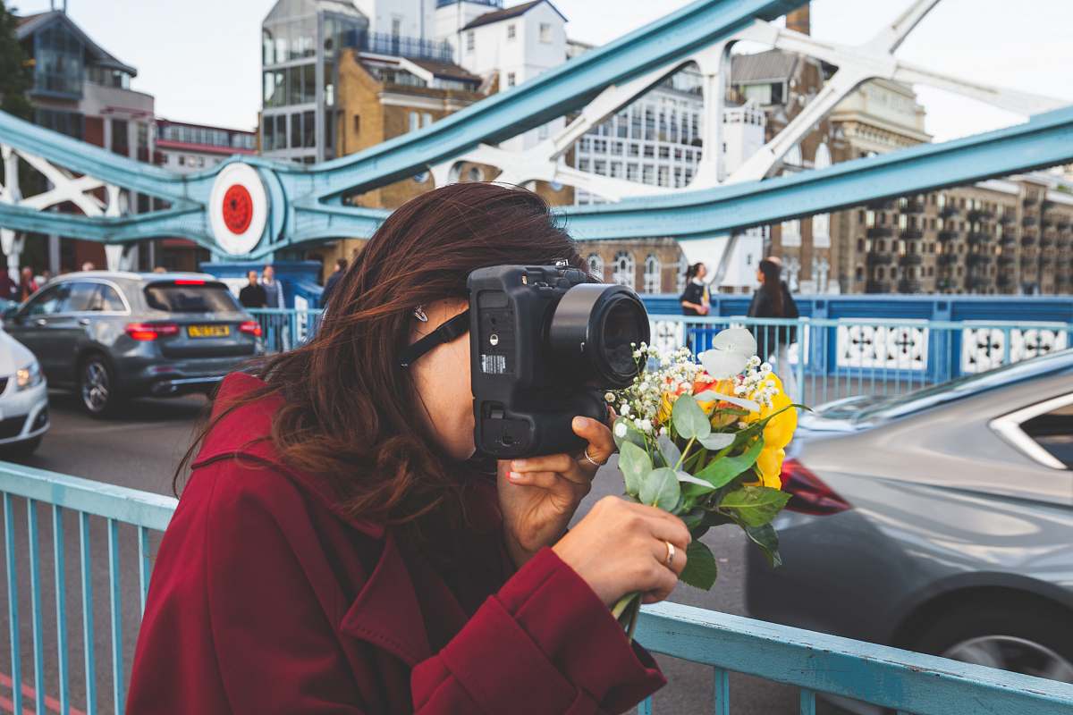 person woman holding black DSLR camera vehicle
