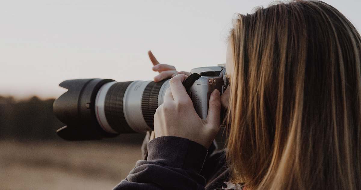 camera woman holding DSLR camera taking photo photography