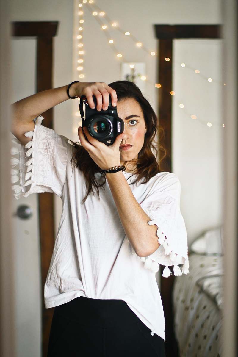 Person woman in white top looking through the camera peephole camera