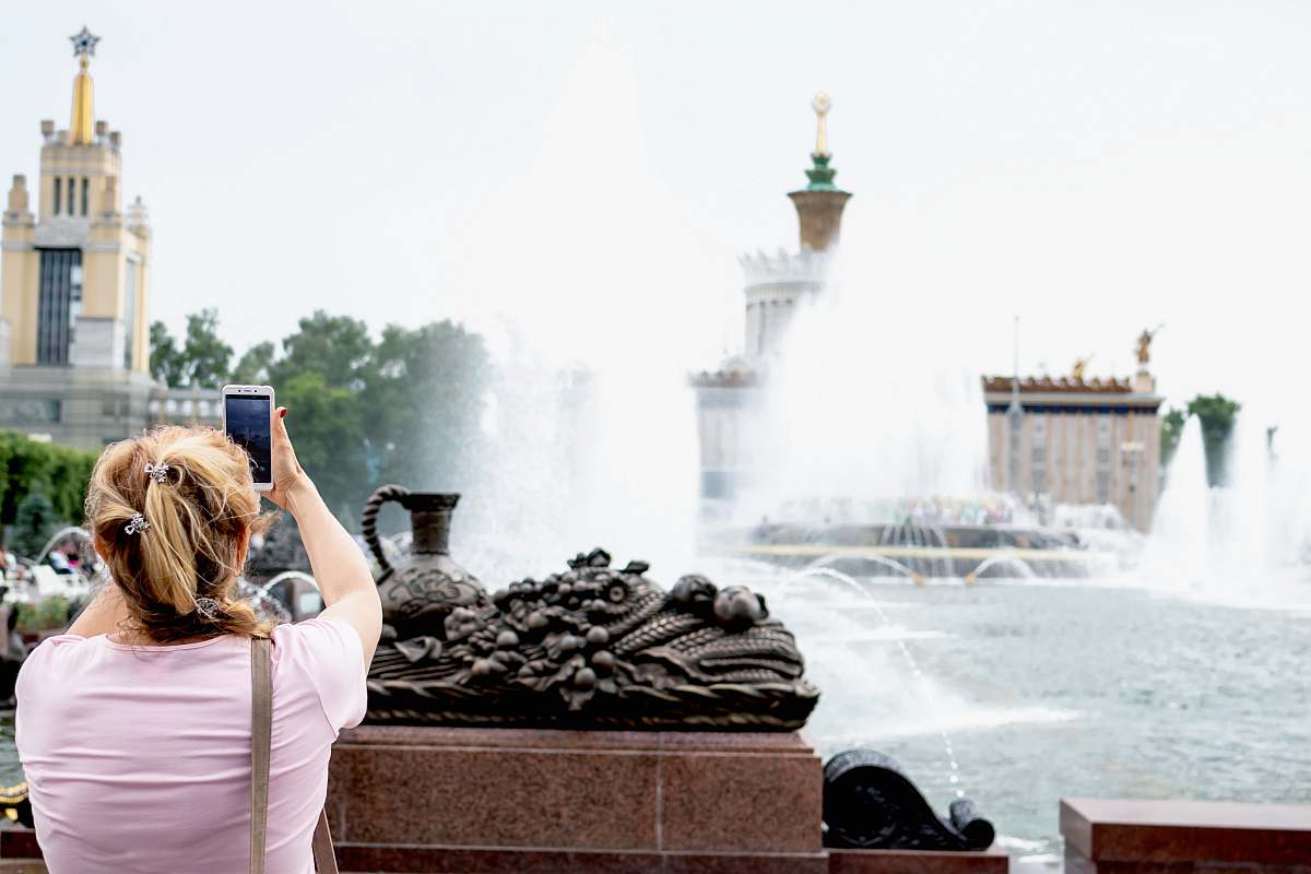 person woman taking photo of water fountain water