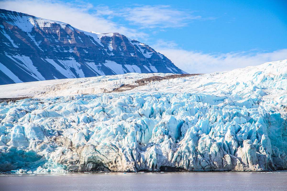 mountain landscape covered by snow beside water glacier
