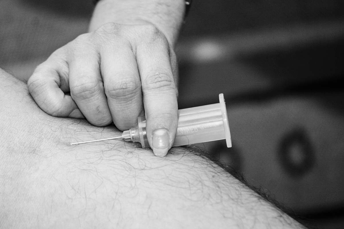 grey grayscale photo of person holding syringe black-and-white