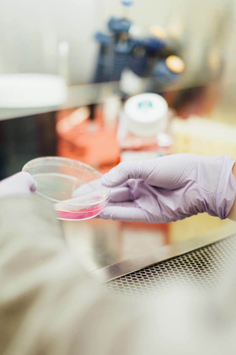 science person holding round clear container test