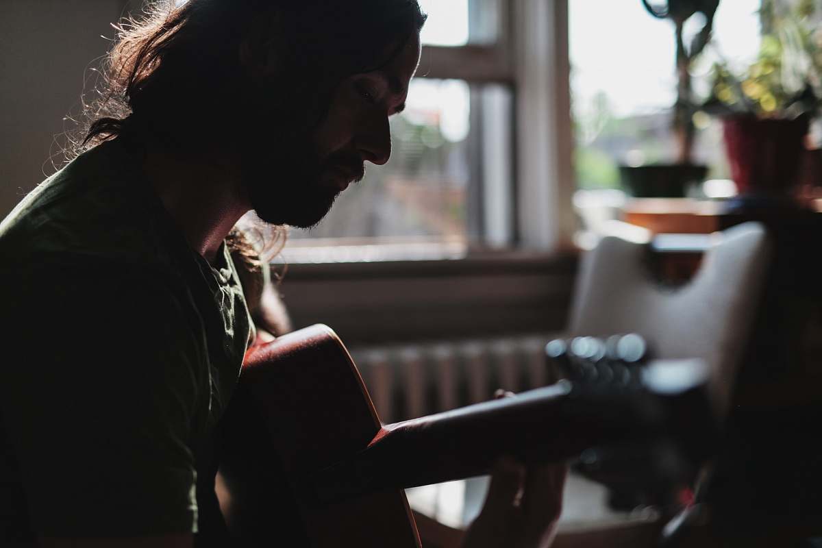 person closeup photo of a man playing guitar people