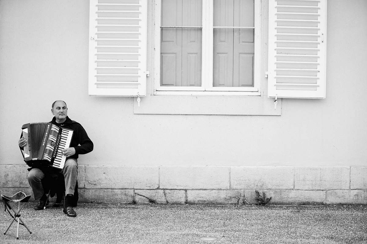 black-and-white grayscale photo of man playing accordion accordion