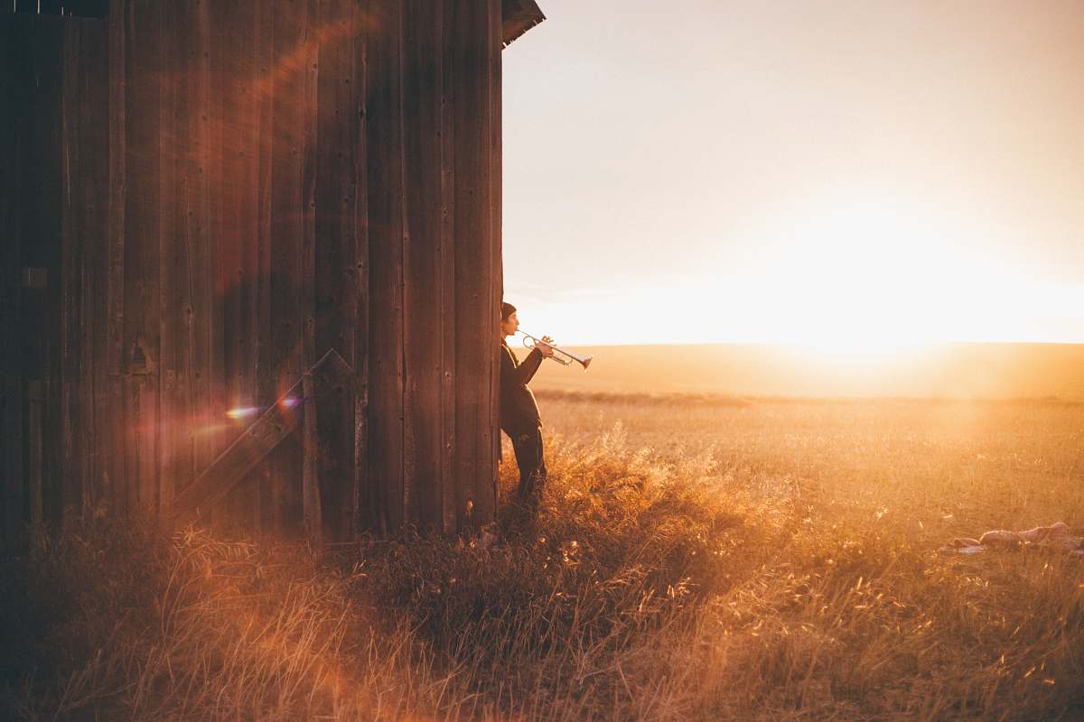 nature man playing trumpet outdoors