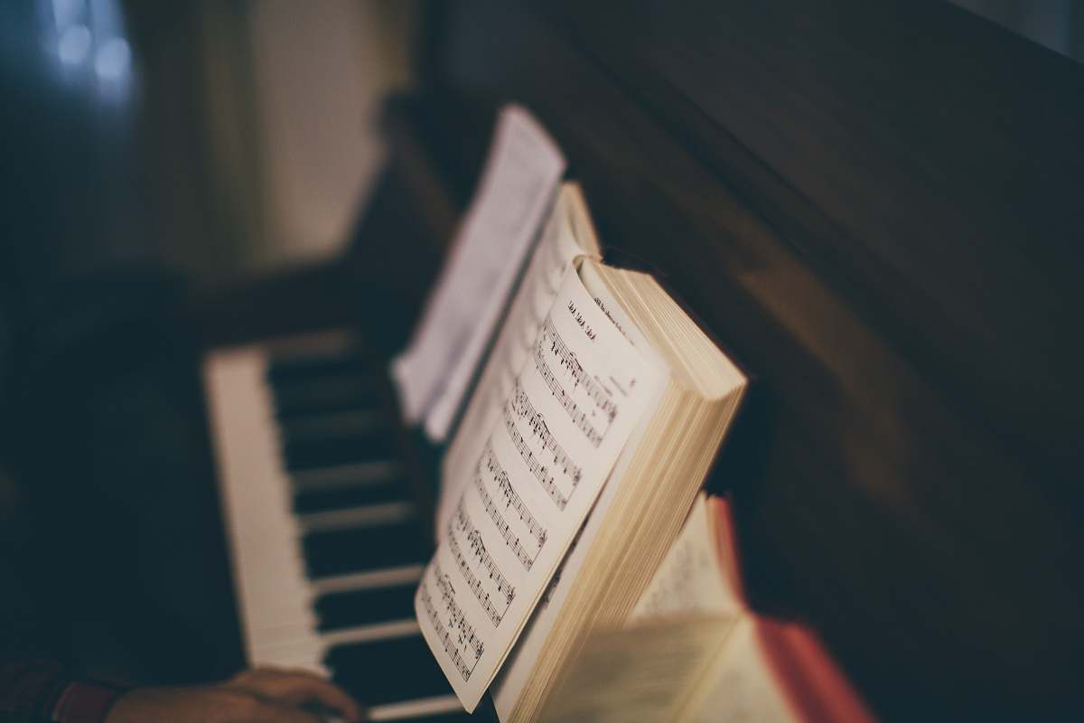 book opened music sheet book on top of upright piano piano