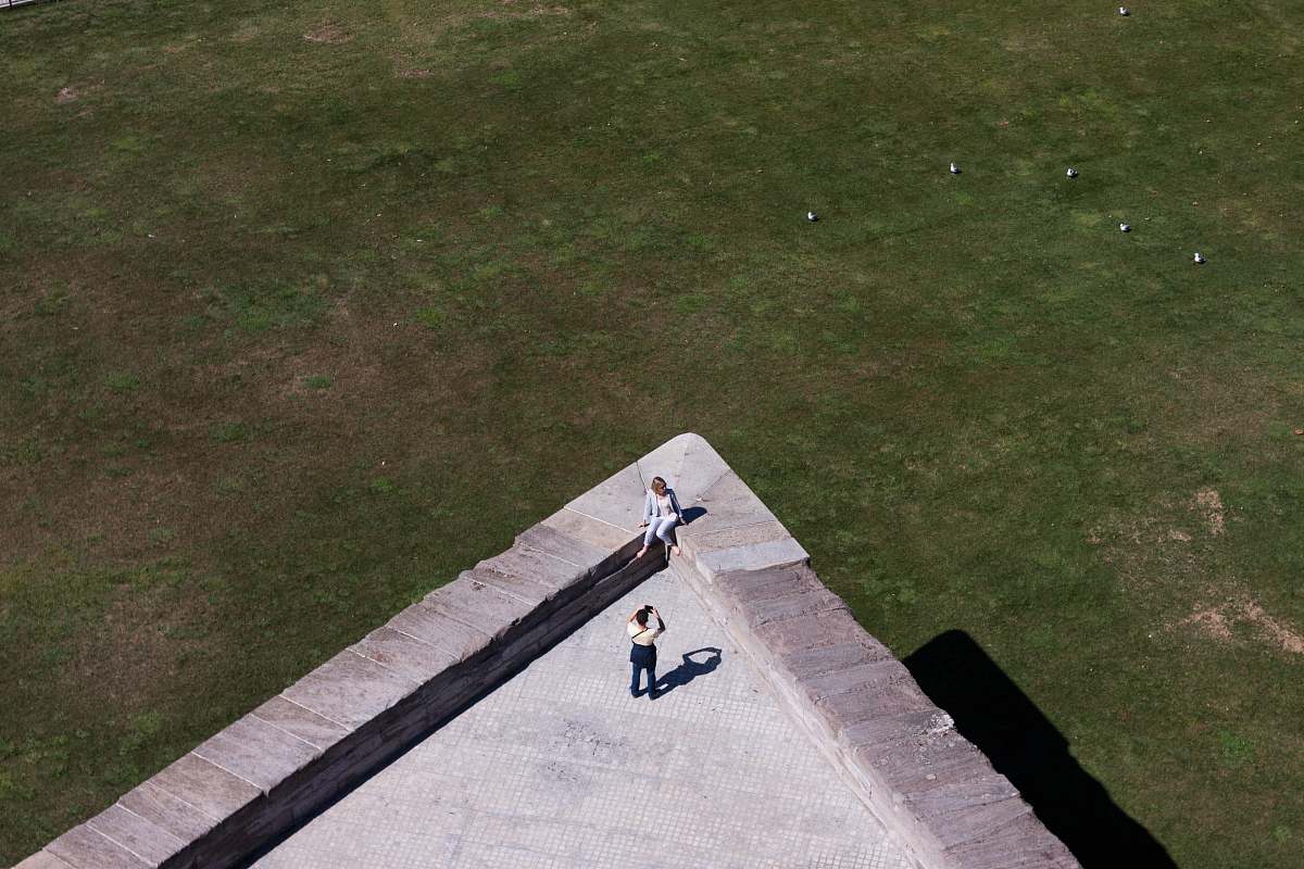 photography aerial photo of two person taking photo on top of building grass