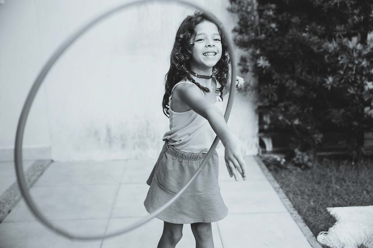 human grayscale photography of girl playing with hula hoop person