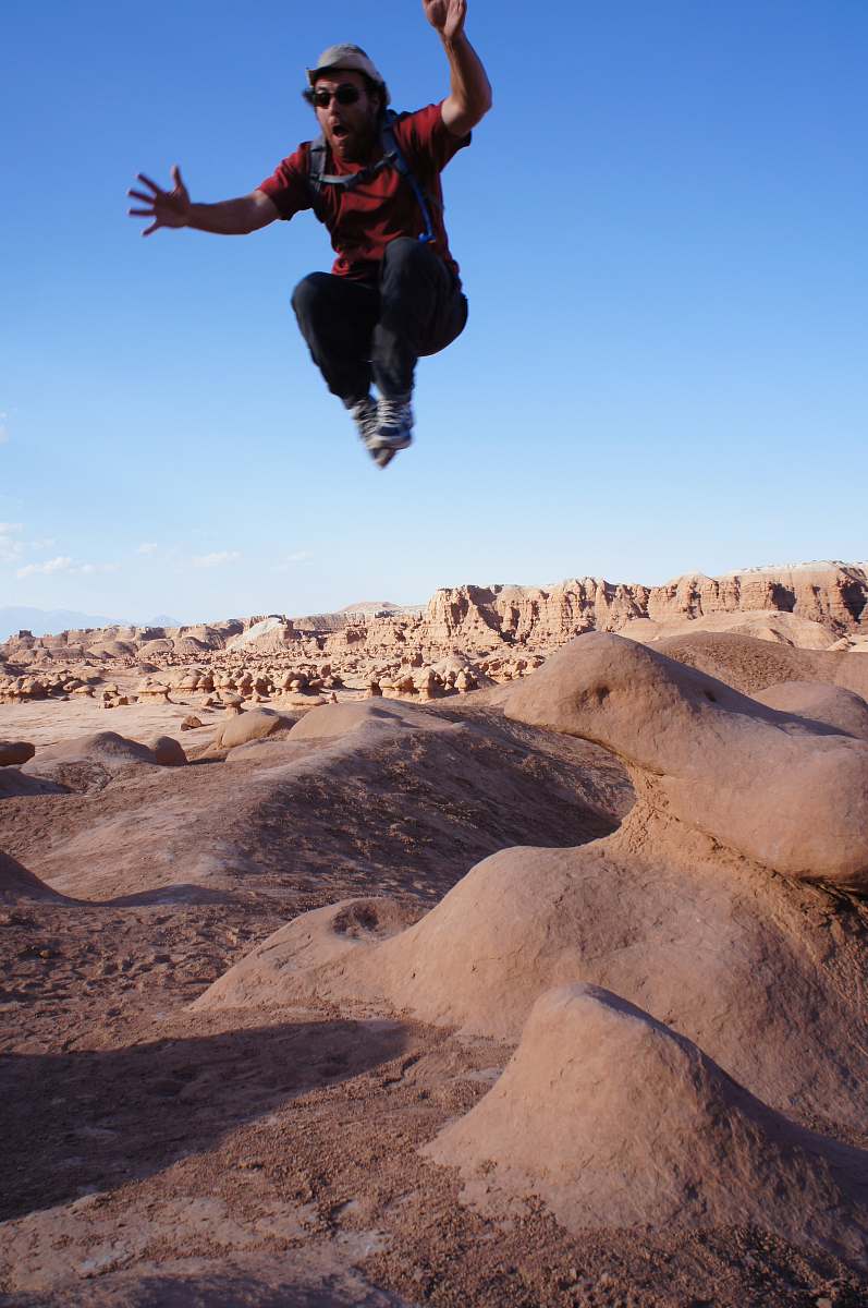human man jumped on desert during daytime person