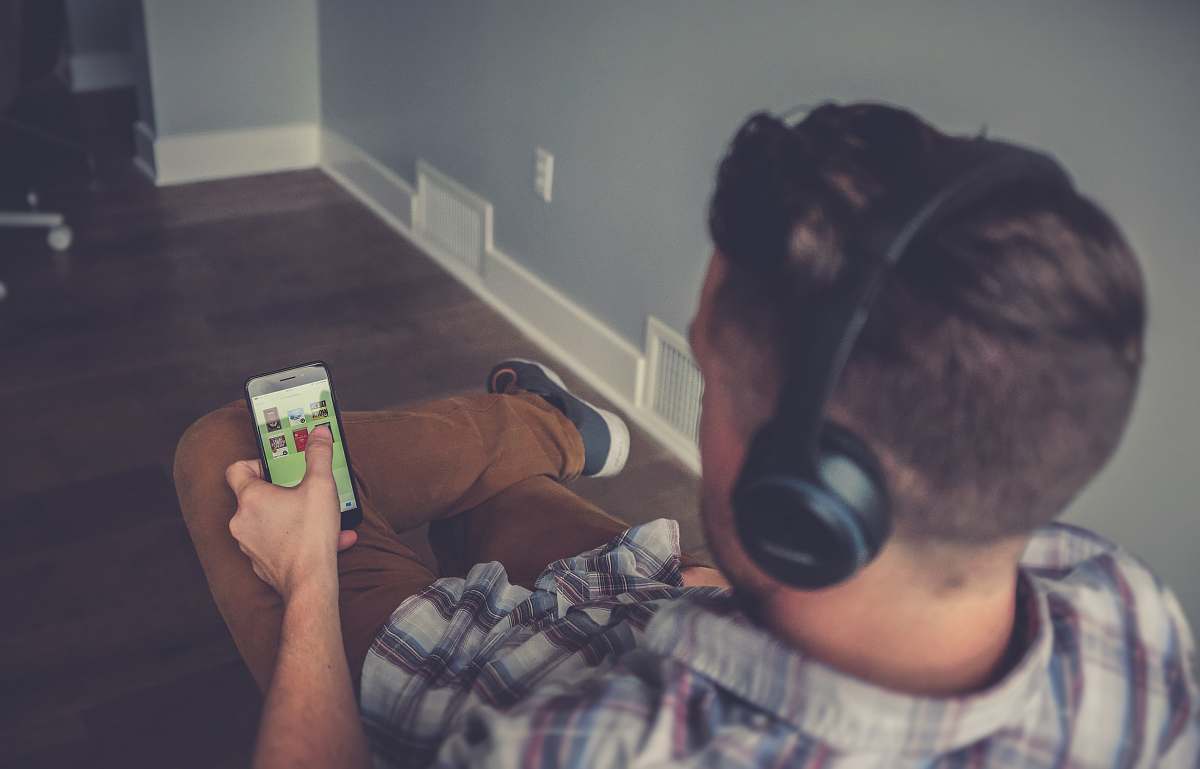 person man using smartphone while using headphones human