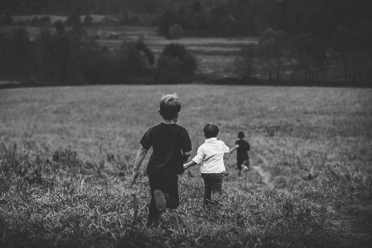 black-and-white three boys running on field grey