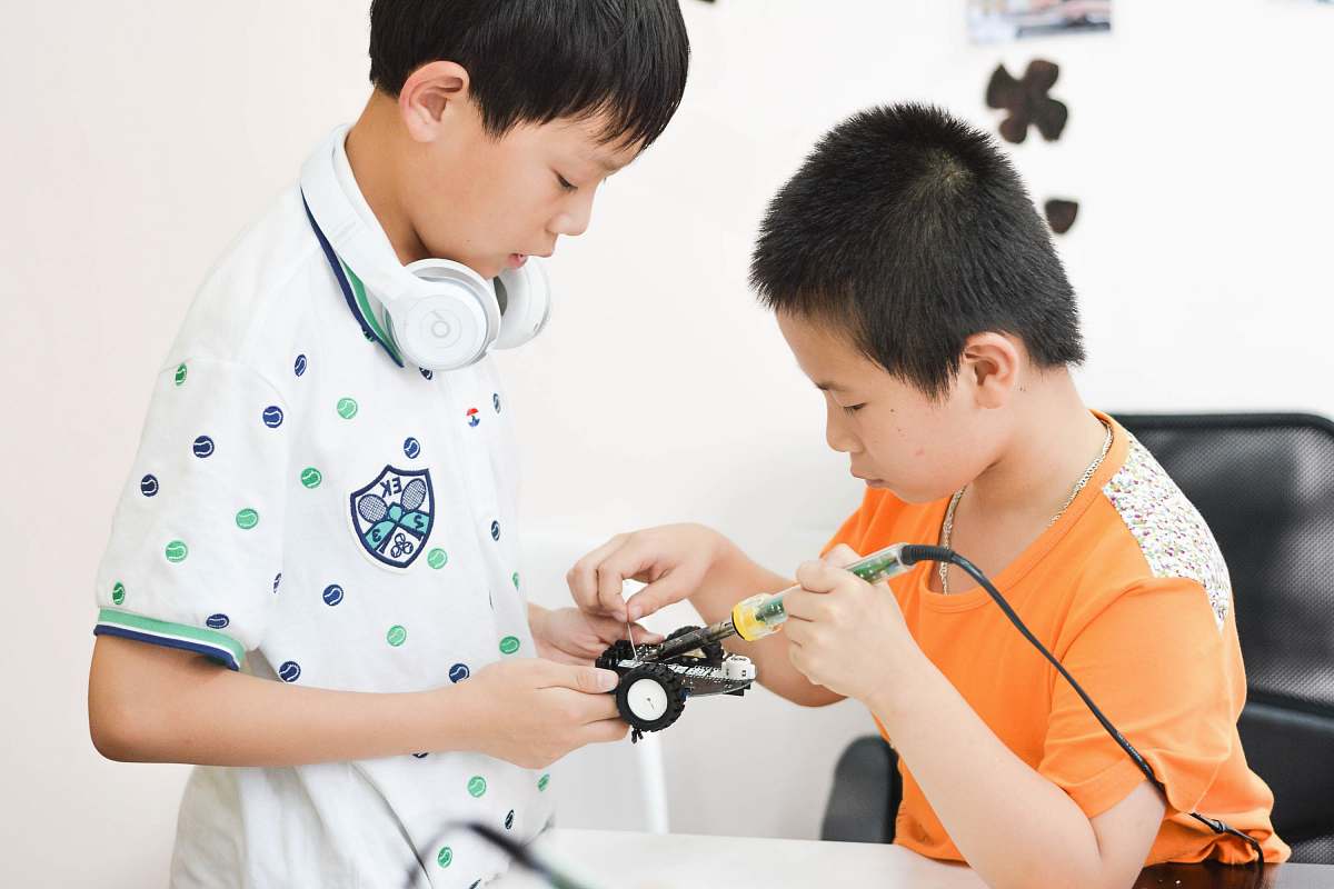 human boy soldering car toy white sitting on chair people