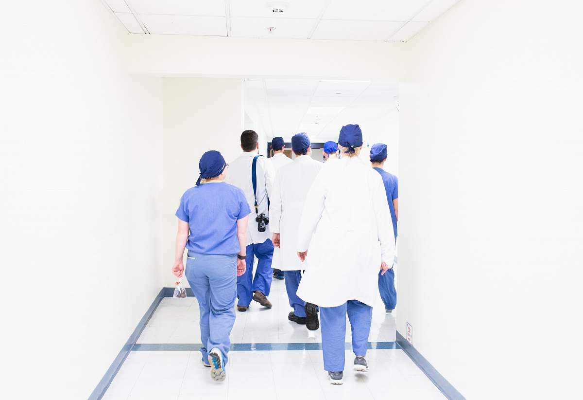 human group of doctors walking on hospital hallway people