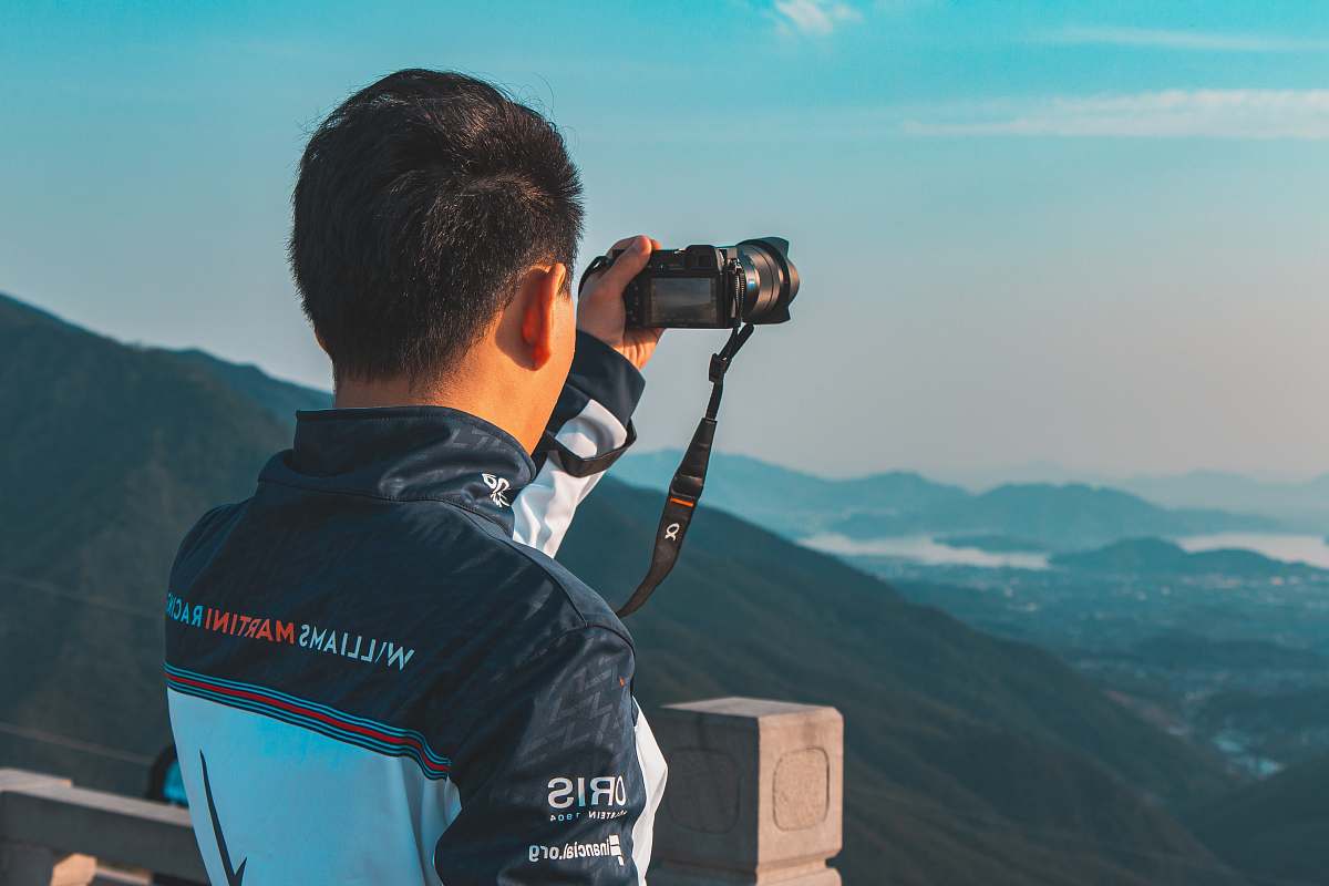 human man holding camera taking photo photo