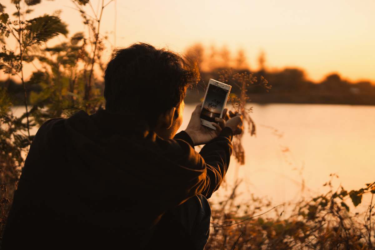 human man holding white smartphone photo