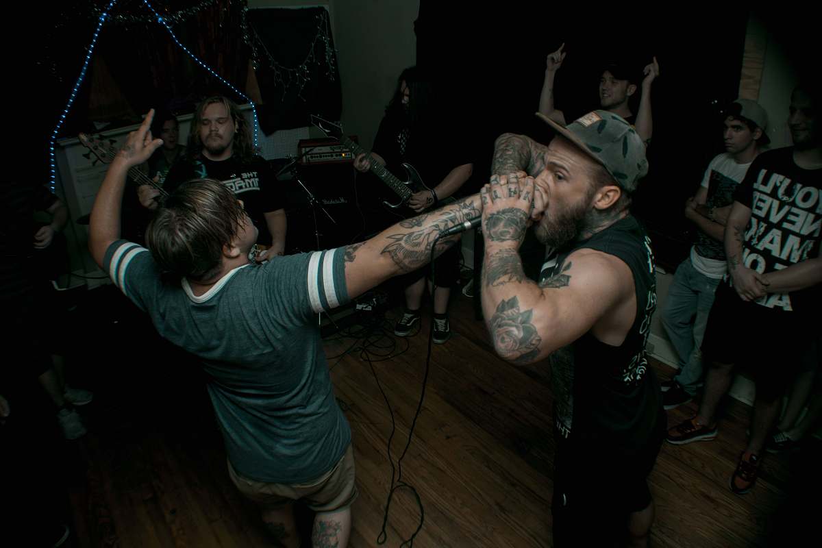 human man holds microphone while singing tattoo