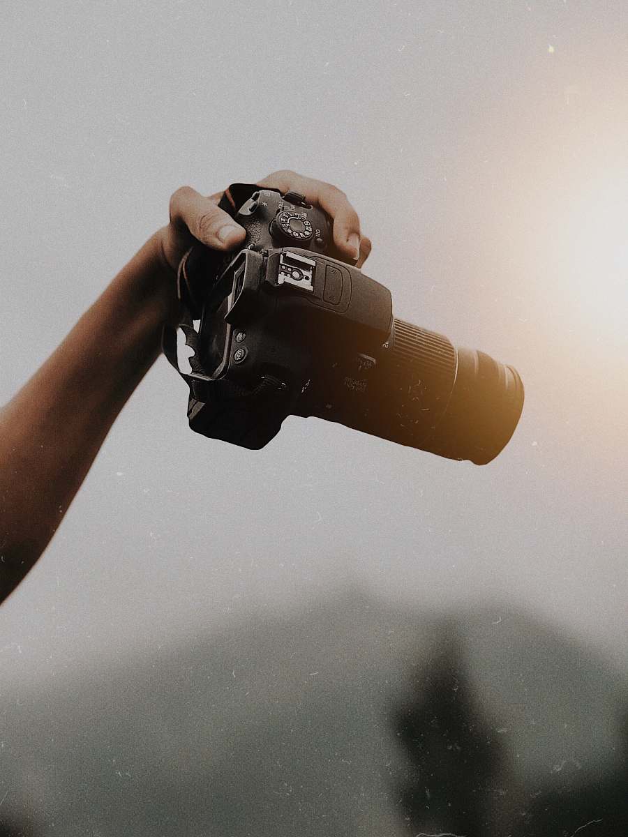 human person holding DSLR camera photo