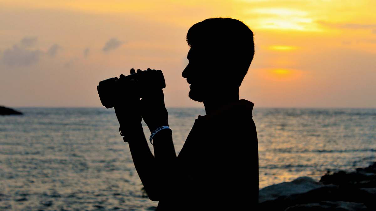 human silhouette of man holding camera photo
