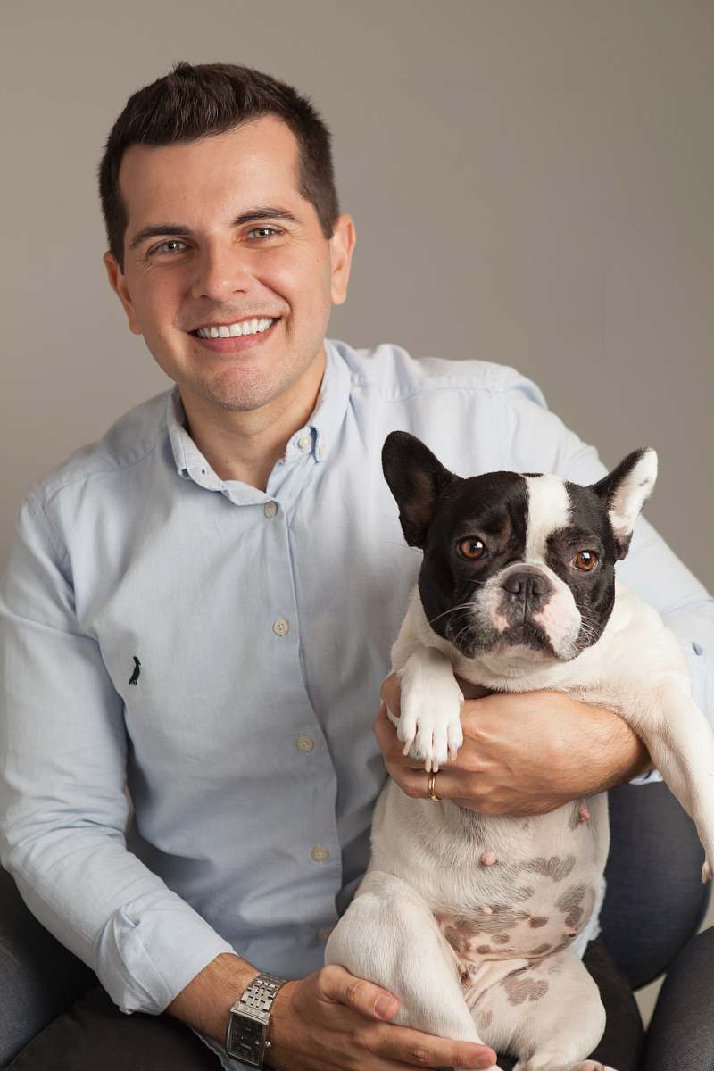 human smiling man holding French bulldog dog
