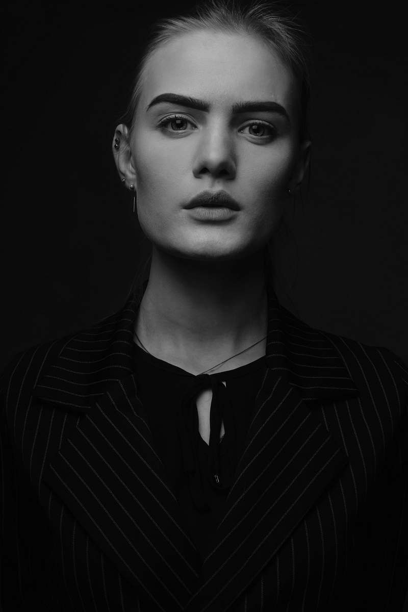 black-and-white woman wearing keyhole top and striped suit jacket face