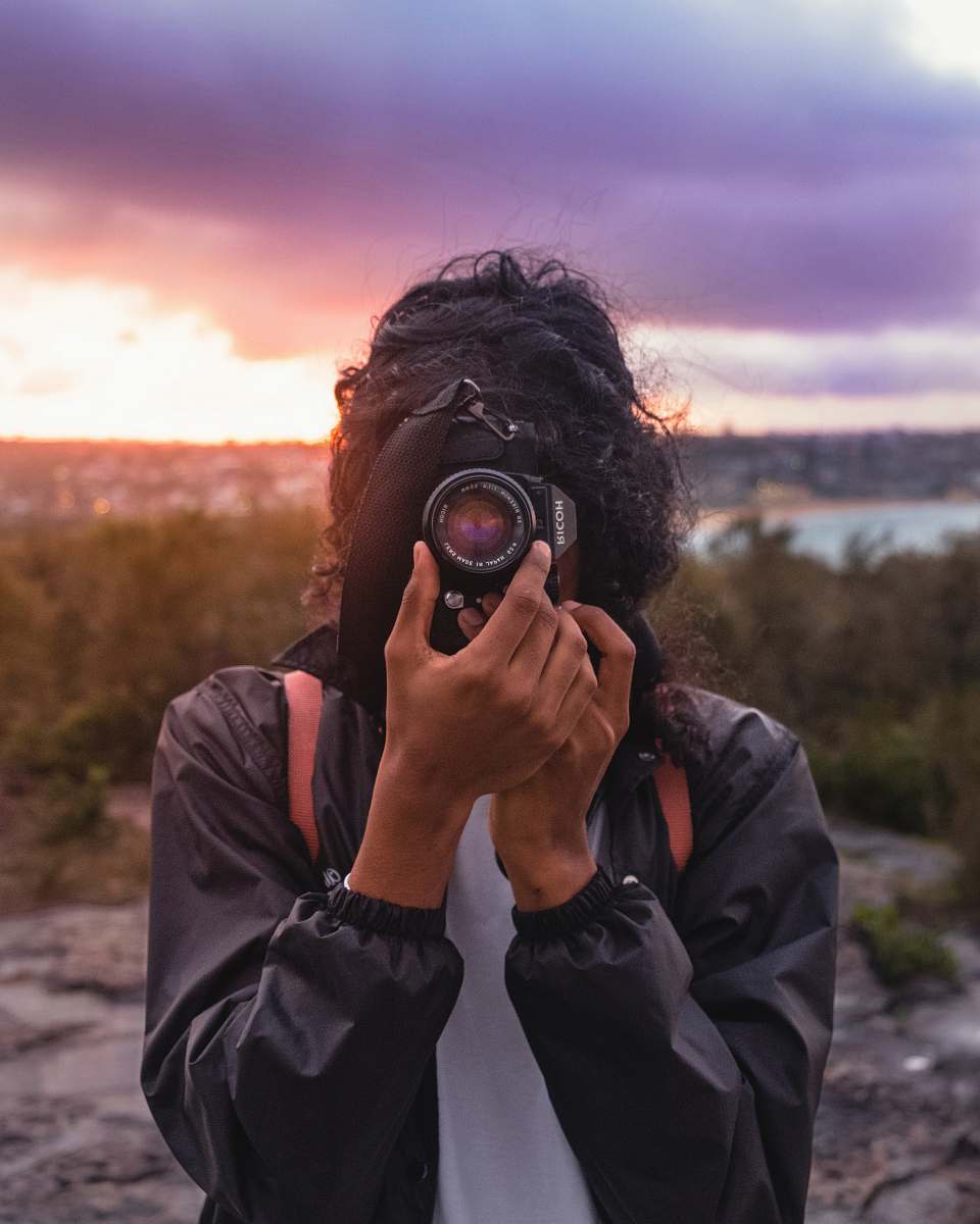 human person wearing black jacket taking picture using DSLR camera person